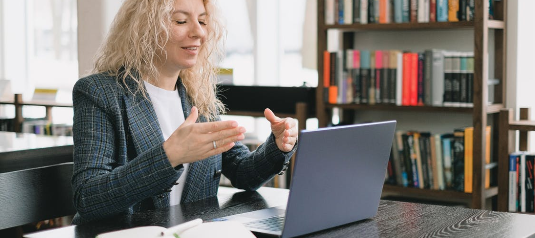 a woman video chatting in a library