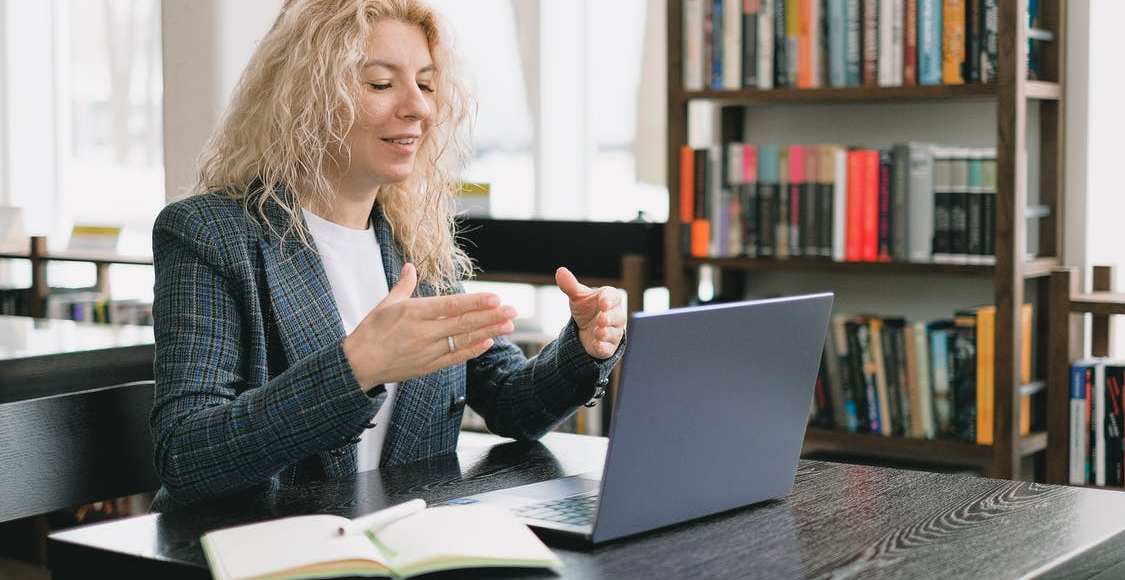 a woman video chatting in a library