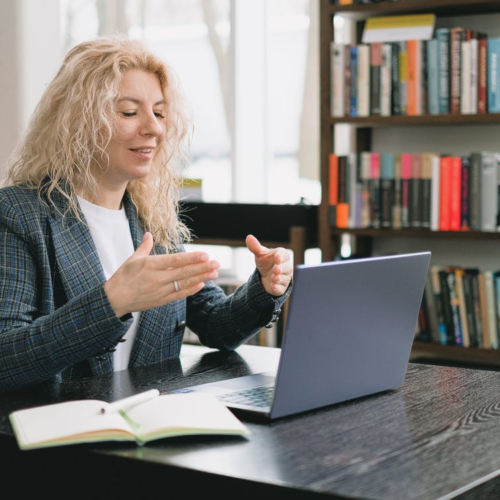 a woman video chatting in a library