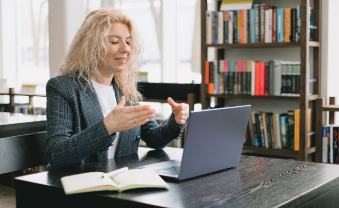 a woman video chatting in a library