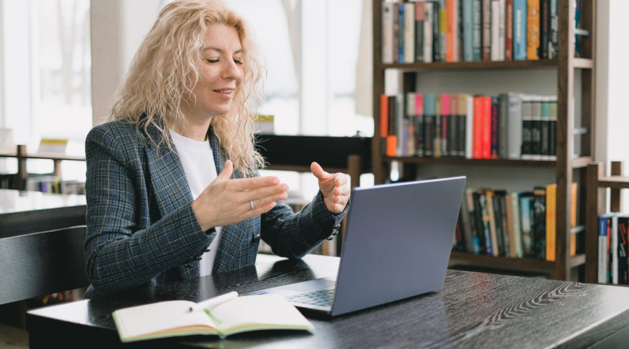 a woman video chatting in a library