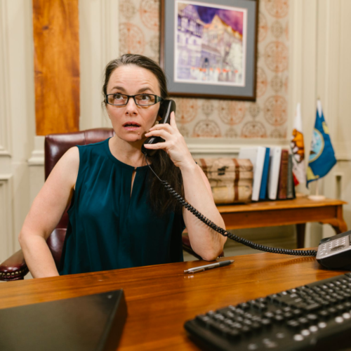 A lawyer works in her office, taking a call.