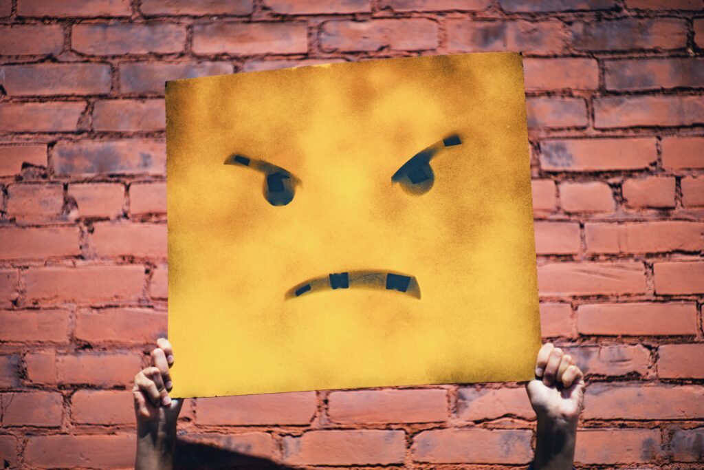 a large square sign with an angry face drawn on