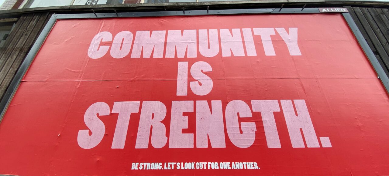 sign saying community is strength