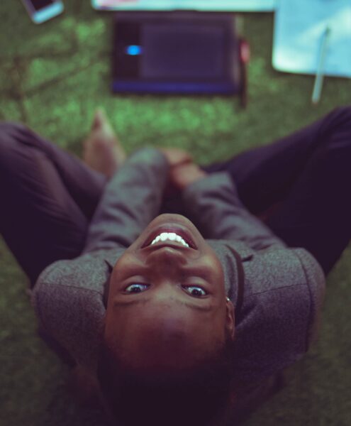 woman smiling at the camera, working on computer