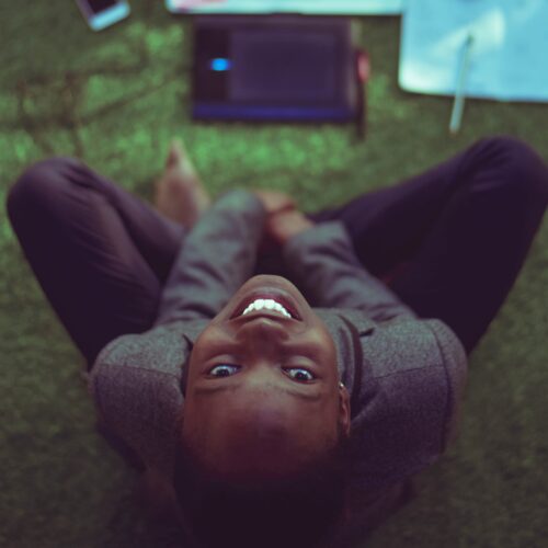 woman smiling at the camera, working on computer