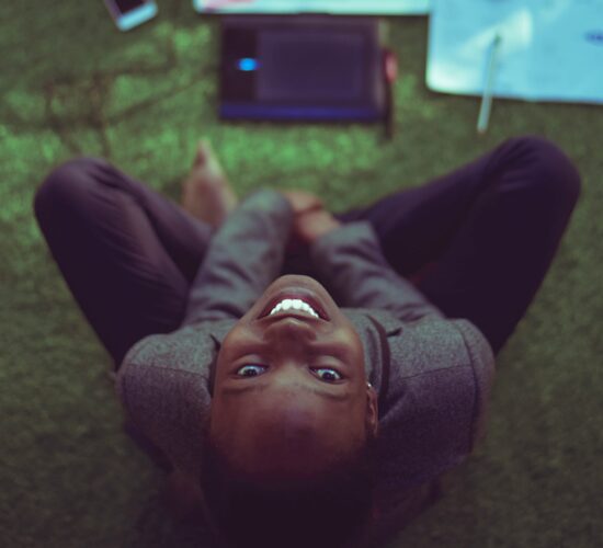 woman smiling at the camera, working on computer