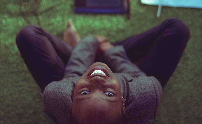 woman smiling at the camera, working on computer