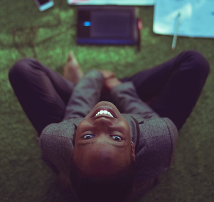 woman smiling at the camera, working on computer