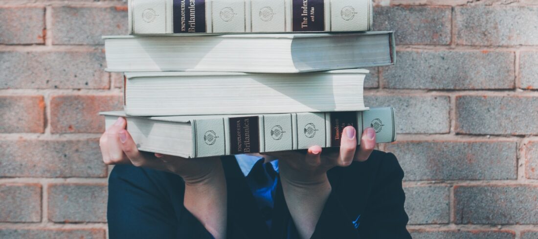 woman holding college textbooks