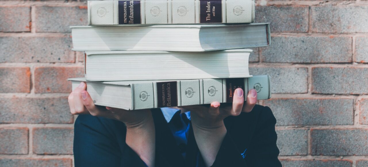 woman holding college textbooks