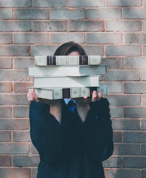 woman holding college textbooks