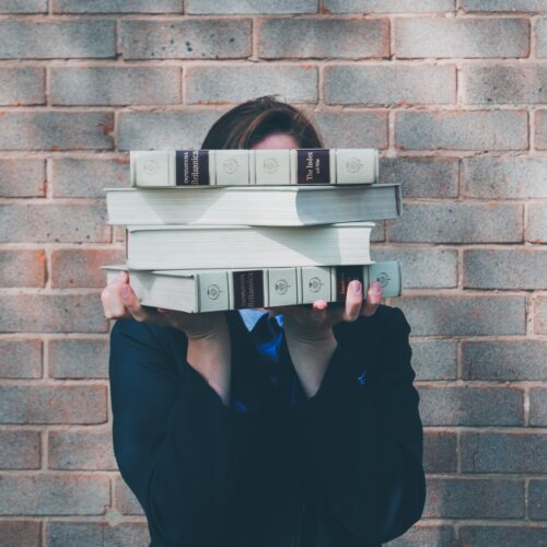 woman holding college textbooks