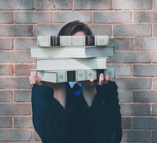 woman holding college textbooks