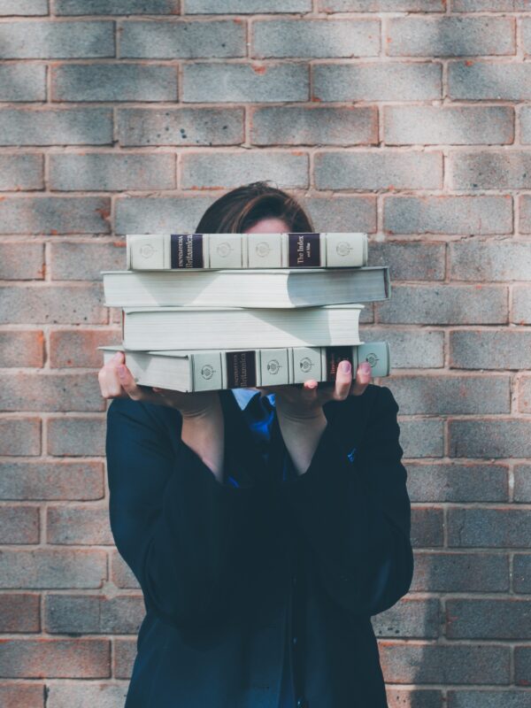 woman holding college textbooks