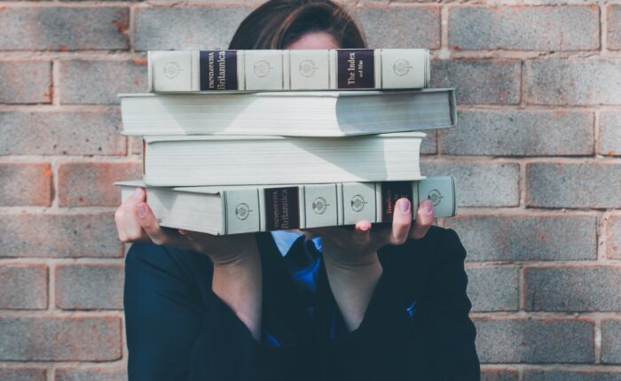 woman holding college textbooks