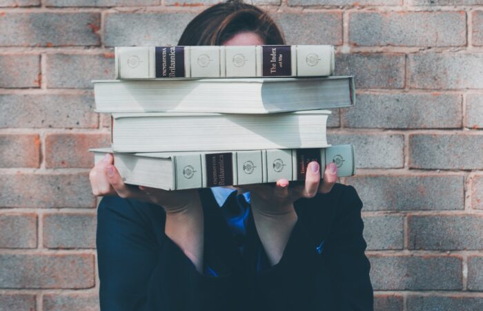 woman holding college textbooks