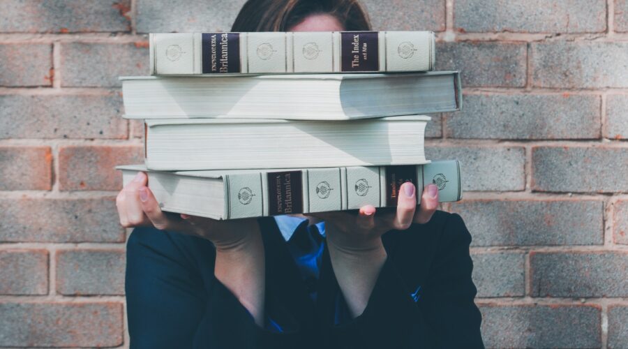 woman holding college textbooks