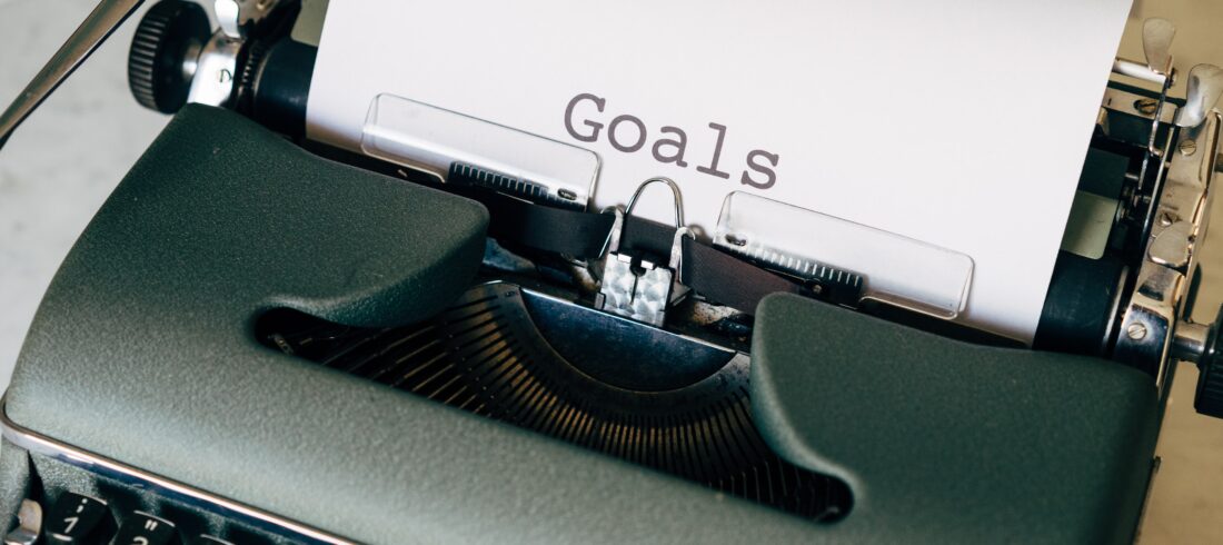 typewriter with paper that says "goals"