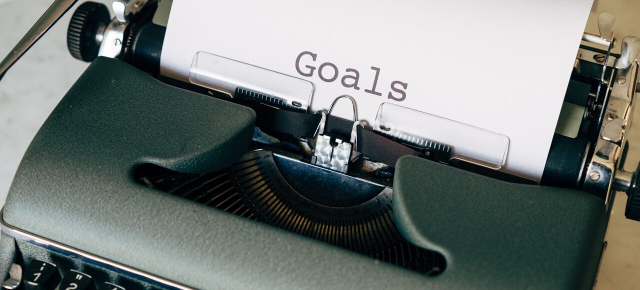 typewriter with paper that says "goals"