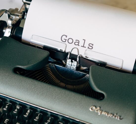 typewriter with paper that says "goals"