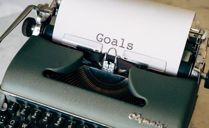 typewriter with paper that says "goals"