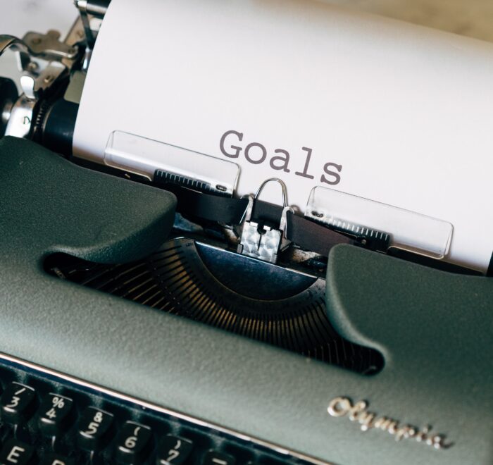 typewriter with paper that says "goals"