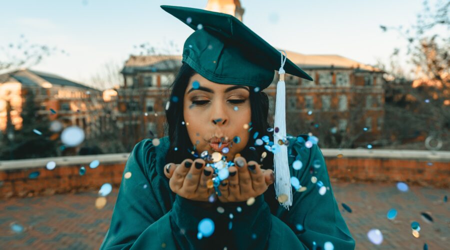 graduate blowing confetti