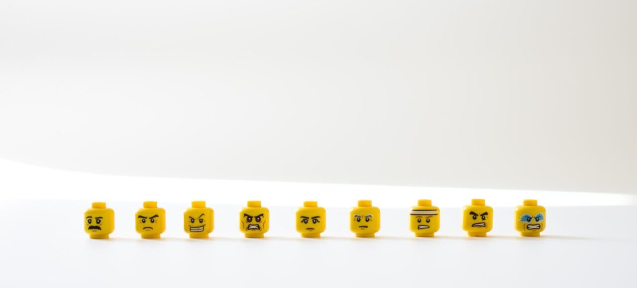 angry lego heads lined up in front of a white background