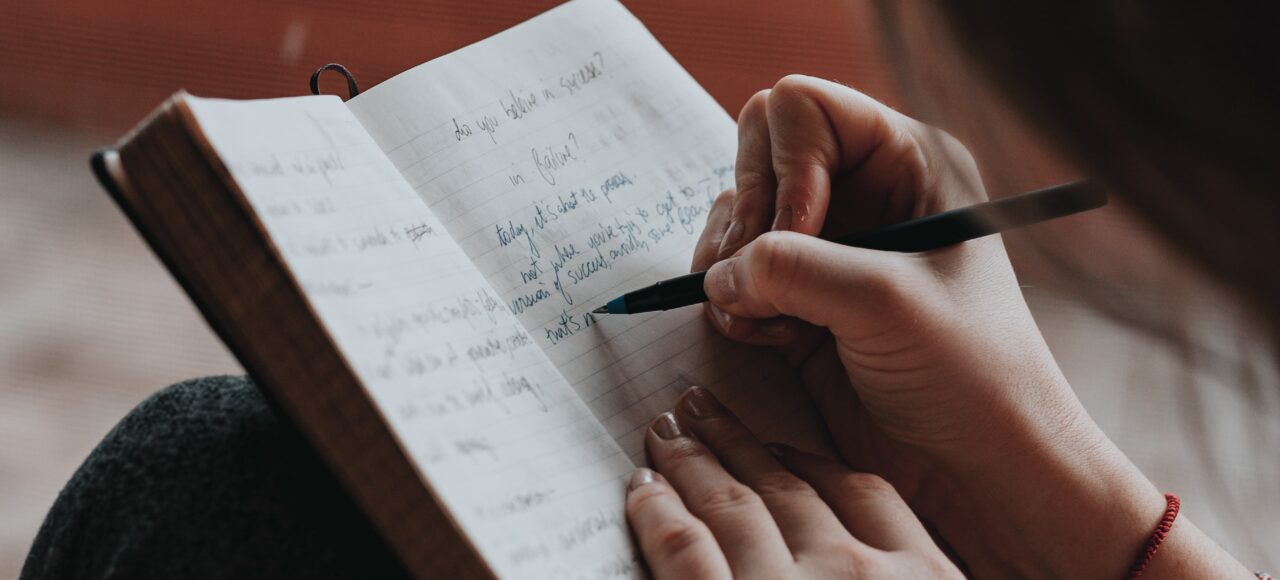 woman writing in journal, learning how to prioritize
