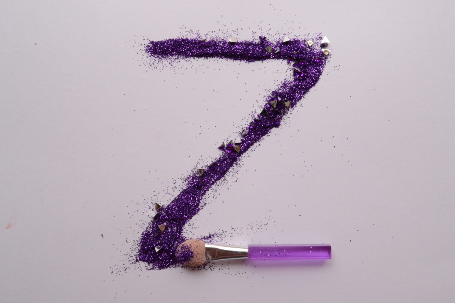 purple glitter makeup spread with a makeup brush to form a 'Z'