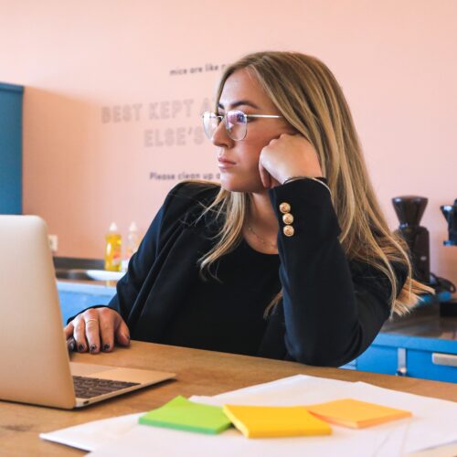 woman in a toxic workplace, bored at laptop