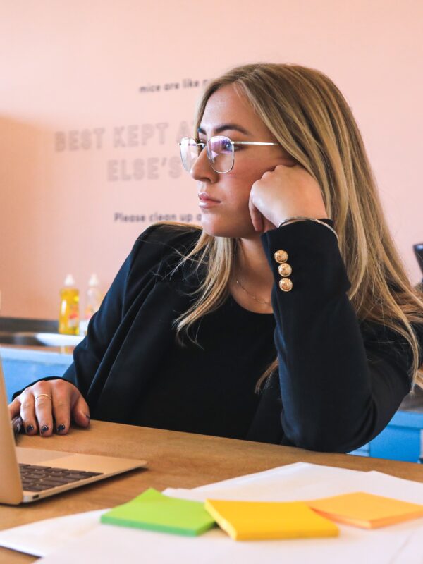 woman in a toxic workplace, bored at laptop