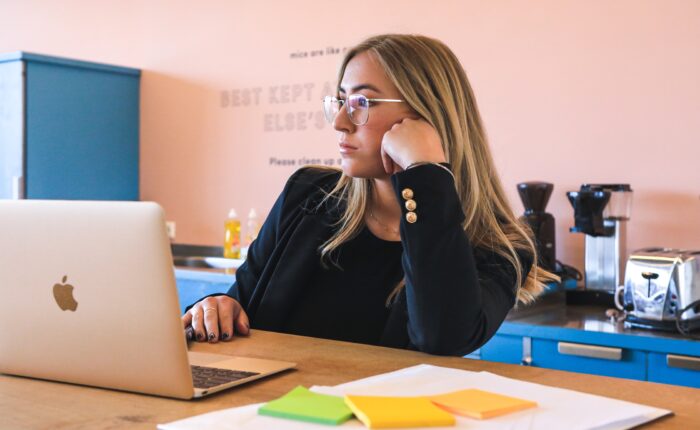 woman in a toxic workplace, bored at laptop