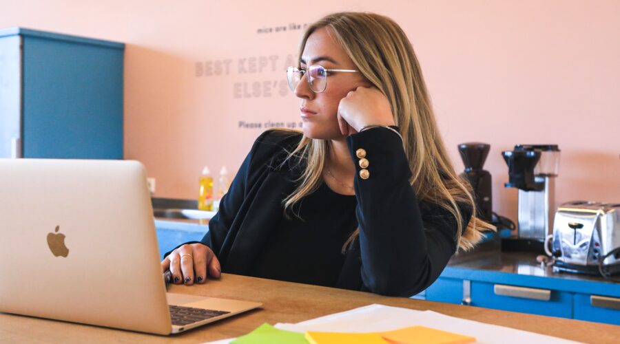 woman in a toxic workplace, bored at laptop