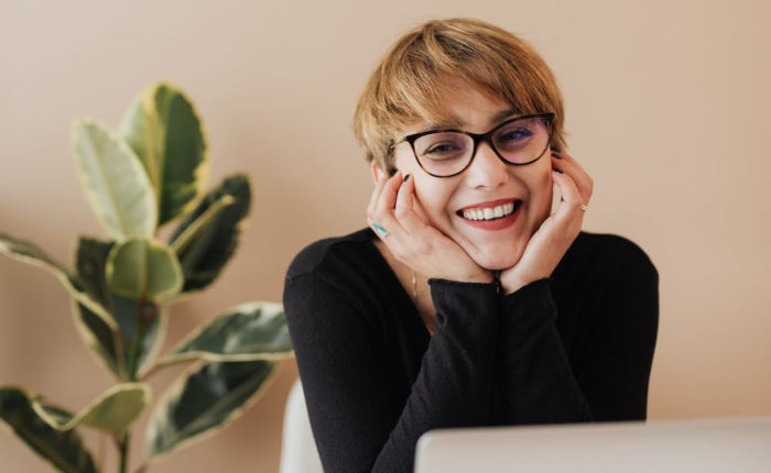 A young student smiles while taking classes online.