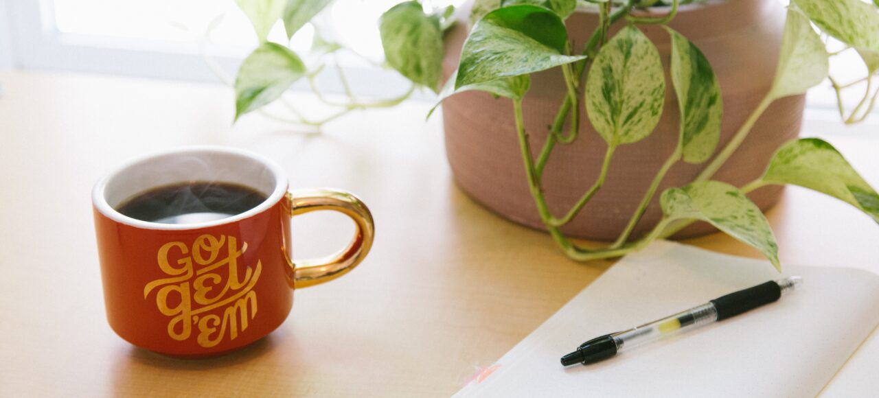 a notebook with a pen and a mug; storytelling in grant writing