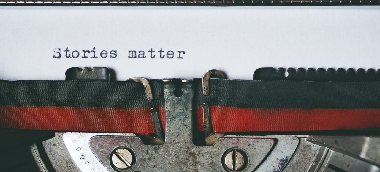 a typewriter with the words "stories matter" typed out; storytelling in grant writing