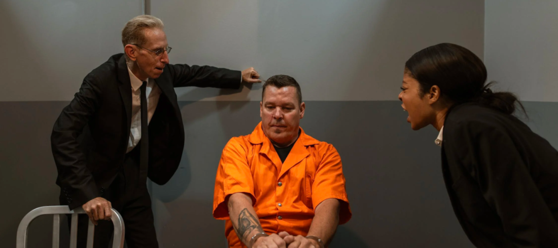 Two criminal justice professionals interrogate a prisoner aggressively