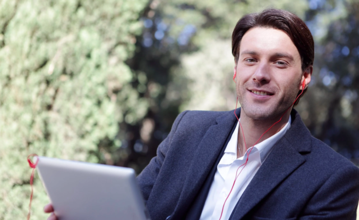 A man smiles while working on his device