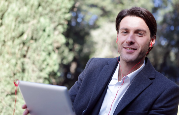 A man smiles while working on his device