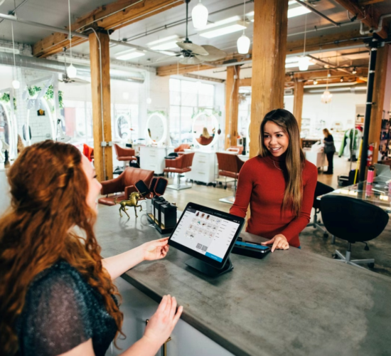 A small business owner smiles at a customer as part of their entrepreneurship ethics