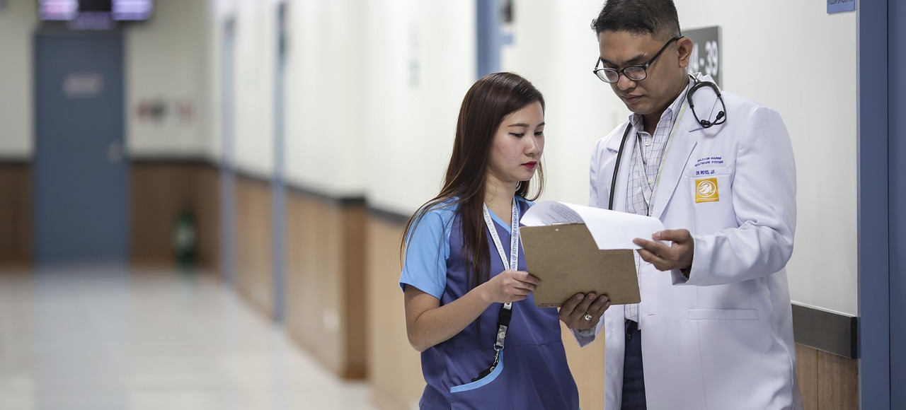 An administrative medical assistant talks to a doctor