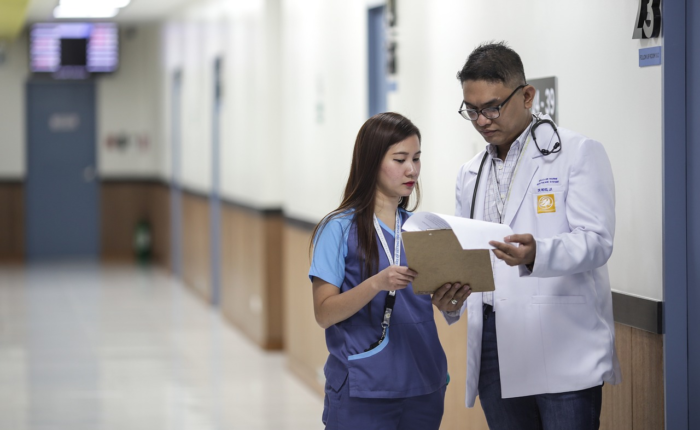 An administrative medical assistant talks to a doctor